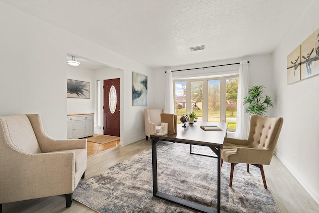 office space featuring light hardwood / wood-style floors and a textured ceiling