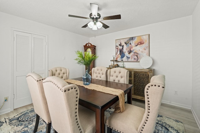 dining area featuring hardwood / wood-style flooring, ceiling fan, and a textured ceiling