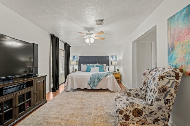 bedroom with ceiling fan and a textured ceiling