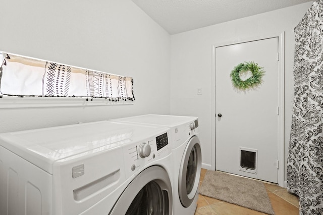 laundry area with light tile patterned flooring and washer and dryer