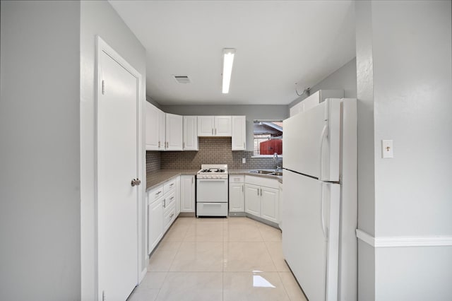 kitchen featuring sink, white appliances, white cabinets, and tasteful backsplash