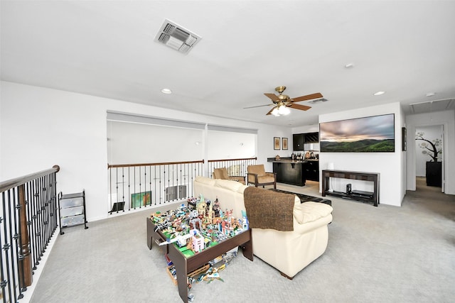 carpeted living area with recessed lighting, visible vents, and attic access