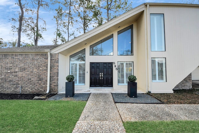 entrance to property with a yard and brick siding