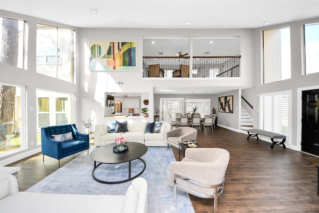 living area featuring stairway, wood finished floors, visible vents, and baseboards