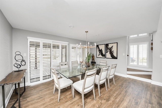 dining room with a chandelier, wood finished floors, and baseboards