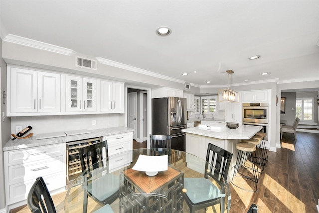 dining area with wine cooler, recessed lighting, visible vents, ornamental molding, and wood finished floors