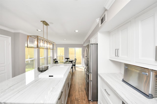 kitchen featuring ornamental molding, dark wood-style flooring, freestanding refrigerator, and a center island