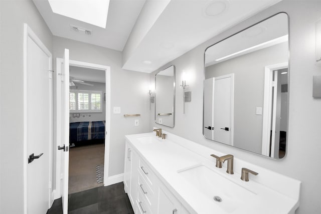 ensuite bathroom with connected bathroom, visible vents, a sink, and double vanity