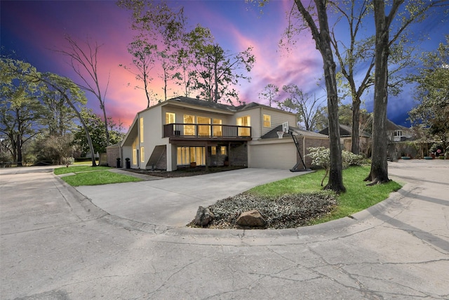 mid-century modern home with concrete driveway, a front lawn, an attached garage, and stucco siding