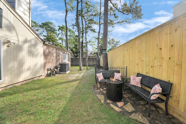 view of yard with an outdoor fire pit, central AC, and fence