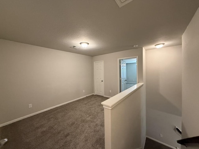 carpeted spare room featuring a textured ceiling