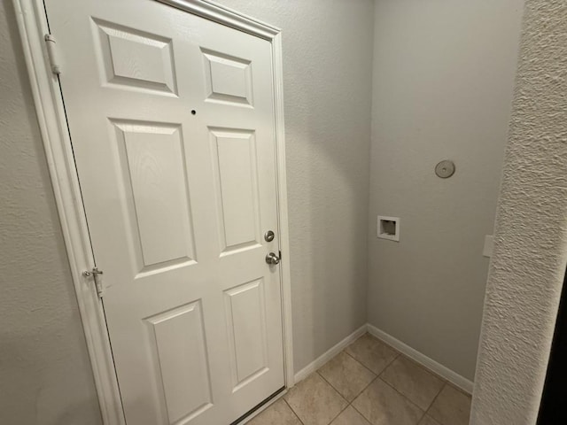 clothes washing area with light tile patterned floors and hookup for a washing machine