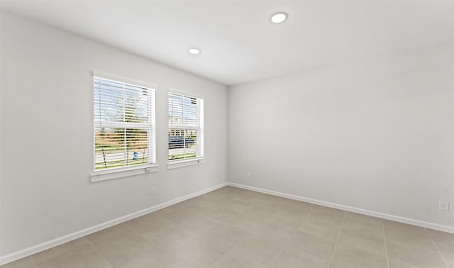 unfurnished room with recessed lighting and baseboards