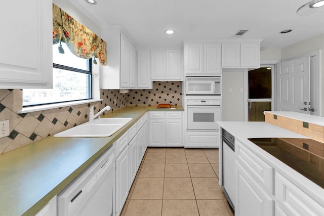 kitchen with sink, white appliances, white cabinets, and light tile patterned floors