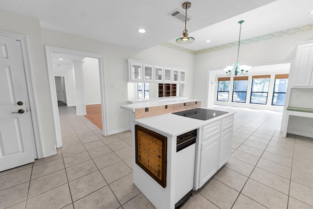 kitchen featuring black electric cooktop, light tile patterned flooring, white cabinetry, and pendant lighting