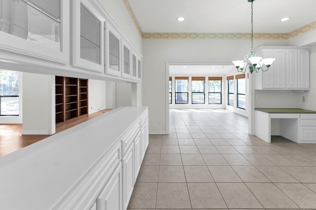 interior space featuring decorative light fixtures, light tile patterned flooring, white cabinetry, and an inviting chandelier