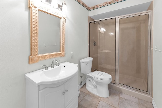 bathroom with vanity, a shower with door, toilet, and tile patterned floors