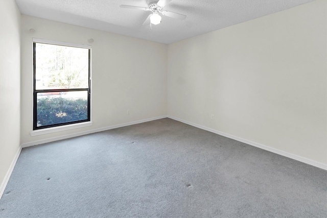 carpeted spare room featuring ceiling fan and a textured ceiling