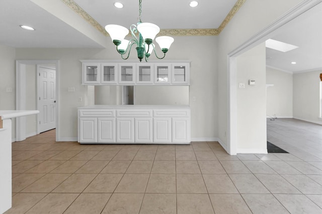 unfurnished dining area featuring ornamental molding, light tile patterned flooring, and a notable chandelier