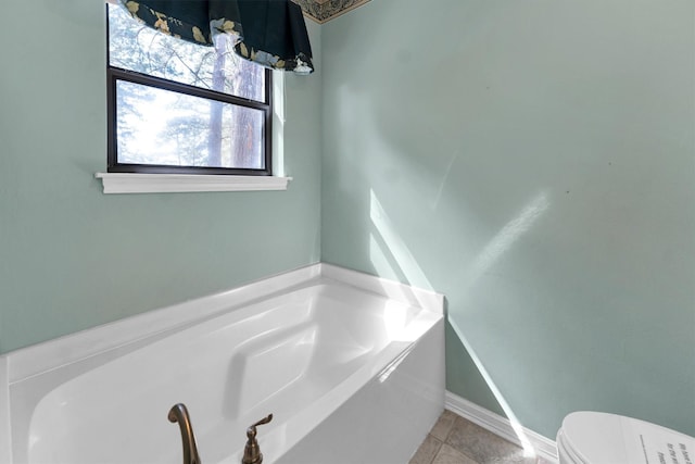 bathroom featuring a bath, toilet, and tile patterned floors