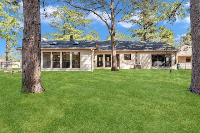 rear view of house featuring a lawn