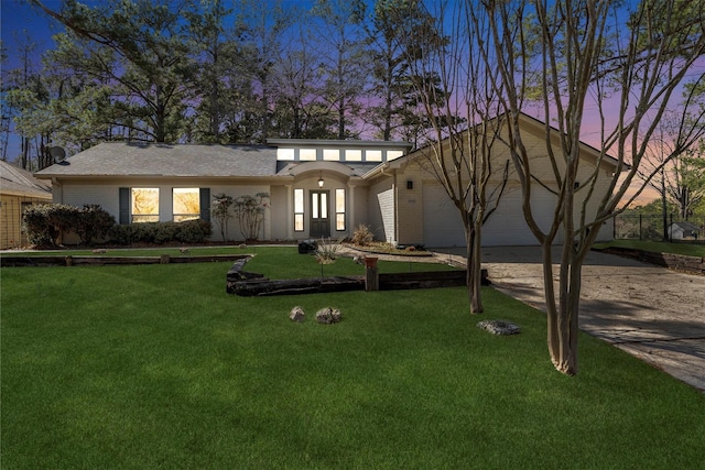 view of front of property featuring a garage and a lawn