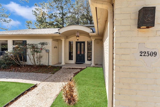 entrance to property featuring a lawn