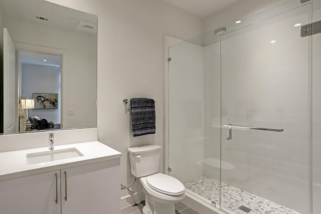 bathroom with toilet, a shower with door, and vanity