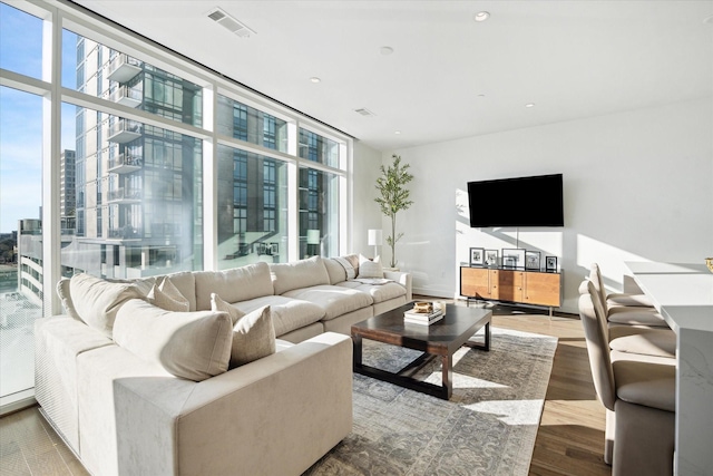 living room featuring a wall of windows and hardwood / wood-style floors