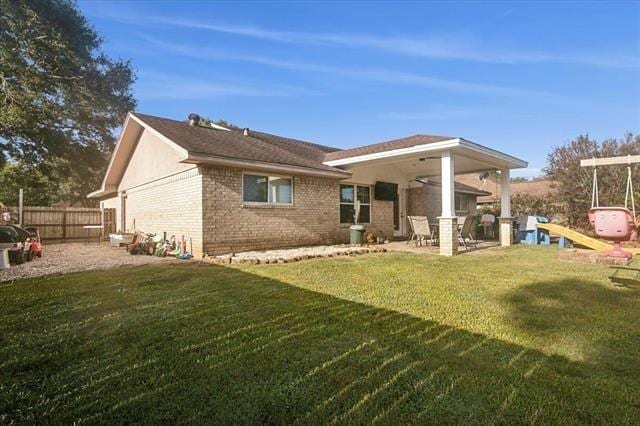 rear view of house featuring a yard, ceiling fan, and a patio area