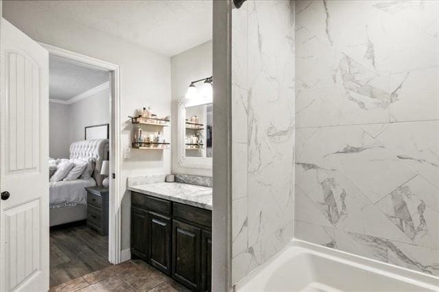 bathroom featuring crown molding, vanity, and tiled shower / bath