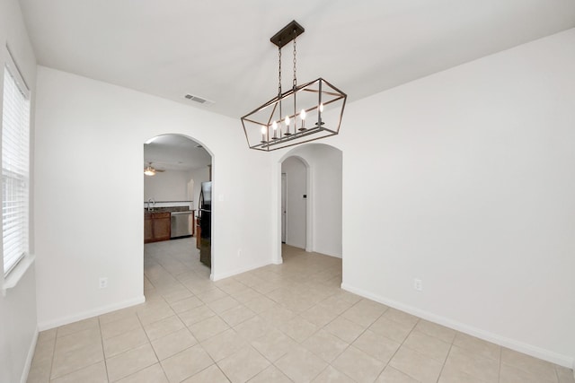 unfurnished dining area with arched walkways, plenty of natural light, visible vents, and a ceiling fan