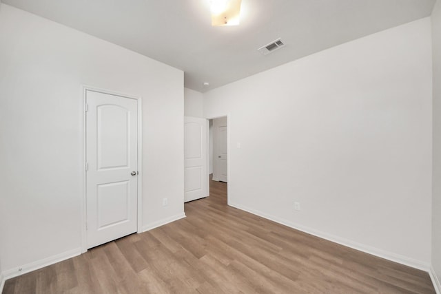 unfurnished bedroom featuring baseboards, visible vents, and light wood finished floors