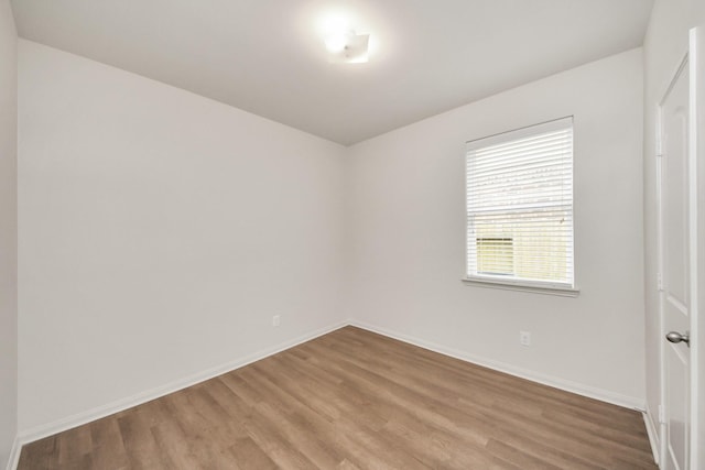 unfurnished room with wood finished floors and baseboards