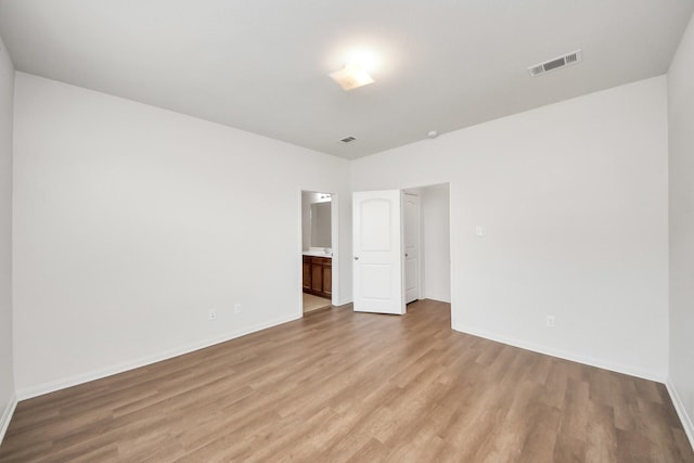 spare room featuring light wood-style floors, baseboards, and visible vents