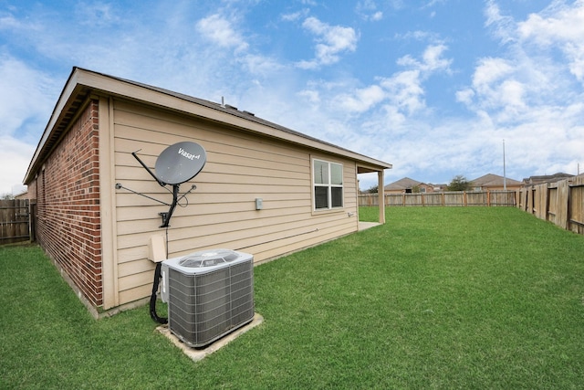 view of home's exterior featuring a fenced backyard, central AC unit, a lawn, and brick siding