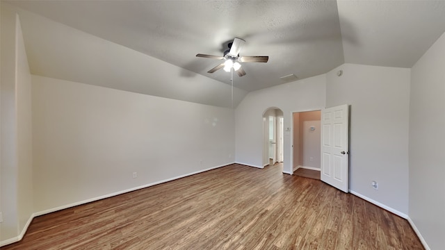 interior space featuring ceiling fan, vaulted ceiling, and wood-type flooring