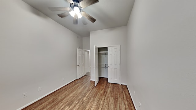 unfurnished bedroom with hardwood / wood-style floors, a closet, and ceiling fan