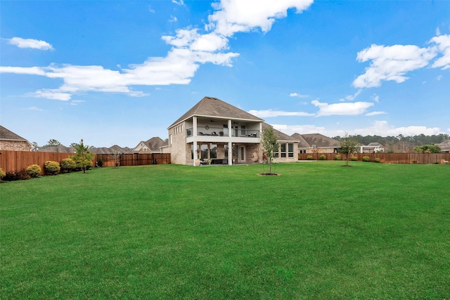 back of property with a yard and a balcony