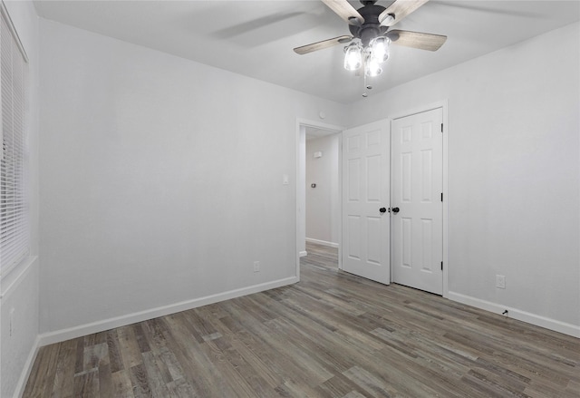 unfurnished bedroom featuring hardwood / wood-style flooring, ceiling fan, and a closet