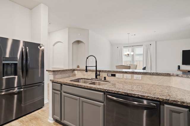 kitchen featuring sink, light stone counters, pendant lighting, gray cabinetry, and stainless steel appliances