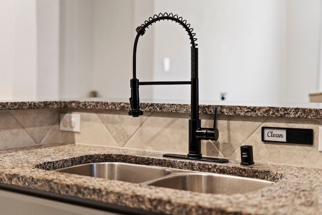 details with sink, backsplash, and dark stone countertops