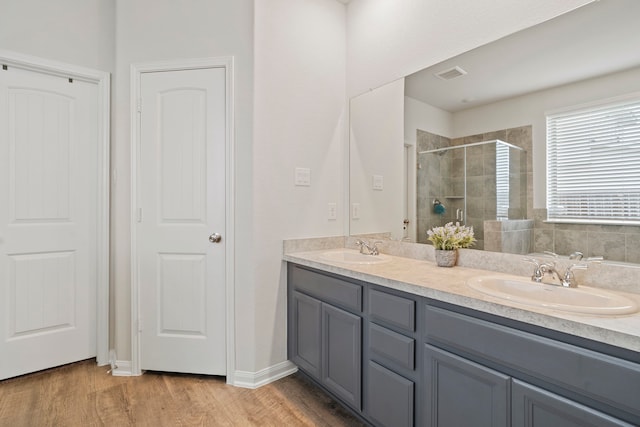 bathroom with an enclosed shower, vanity, and hardwood / wood-style floors