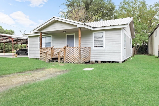 view of front of home with a front yard and a carport