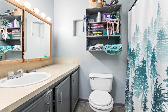 bathroom featuring wood-type flooring, vanity, a shower with shower curtain, and toilet