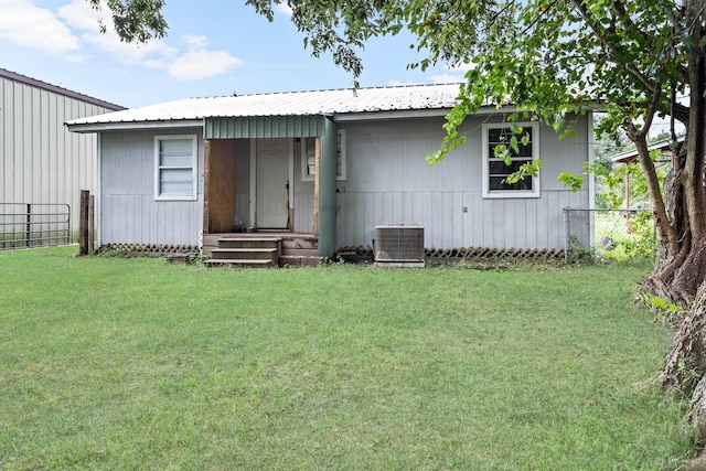 view of front facade featuring a front lawn and central air condition unit