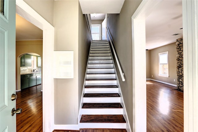 stairs featuring wood-type flooring and sink