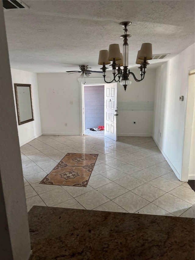 unfurnished dining area with a textured ceiling, a chandelier, and light tile patterned floors