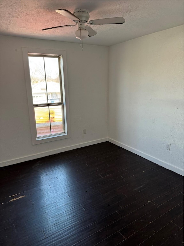 empty room featuring dark hardwood / wood-style flooring, ceiling fan, and a textured ceiling