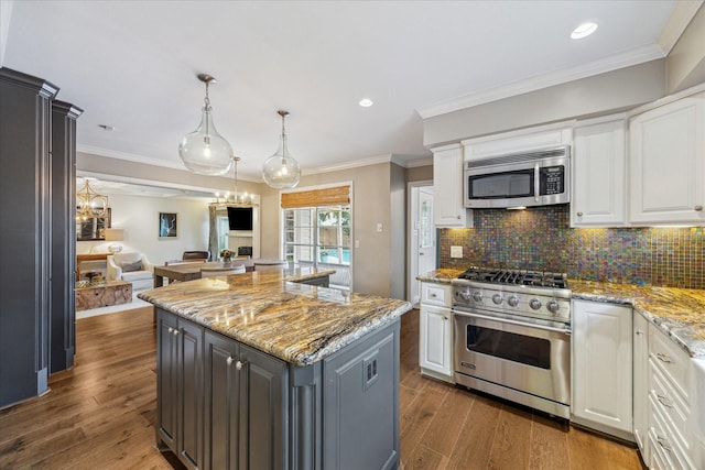 kitchen featuring white cabinetry, gray cabinetry, a kitchen island, light stone counters, and appliances with stainless steel finishes